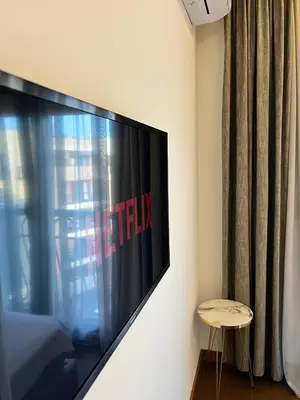 a flat screen tv hanging on a wall next to a window at Montenegro Prestige Suite in Podgorica