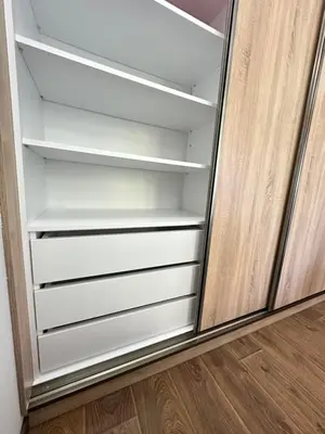 a closet with white shelves and a wooden floor at Apartman T&T in Cetinje