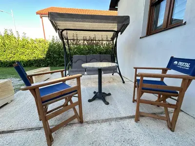 two chairs and a table and a chair and a swing at Apartman T&T in Cetinje