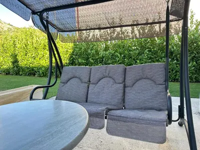 a couch sitting under a table in a patio at Apartman T&T in Cetinje