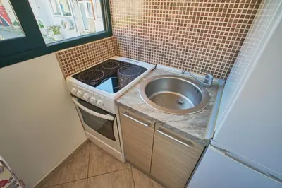a small kitchen with a sink and a stove at Apartman Sveti Stefan in Sveti Stefan