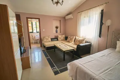 a living room with a couch and a bed and a tv at Apartman Sveti Stefan in Sveti Stefan