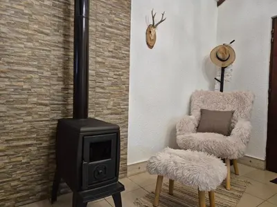 a living room with a wood stove and a chair at Castio del Monte Winery & Resort in Petrovac na Moru