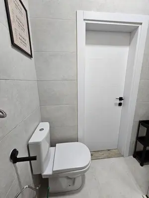 a bathroom with a white toilet and a door at Cloud 9 Apartment in Lajkovići