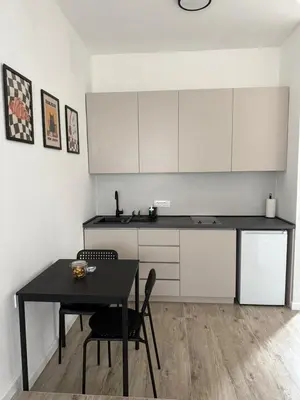 a kitchen with a black table and white cabinets at Cloud 9 Apartment in Lajkovići
