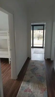 an empty room with a hallway with a door and a rug at Ars Dobra Voda in Dobra Voda