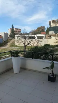 a balcony with two potted plants and a tree at Ars Dobra Voda in Dobra Voda