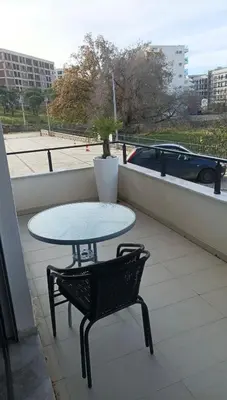 a table and a chair sitting on a balcony at Ars Dobra Voda in Dobra Voda