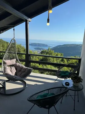a swinging chair on a porch with a view at CASA HOME, one-bedroom home in Stanišiči