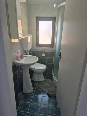 a bathroom with a toilet and a sink and a window at CASA HOME, one-bedroom home in Stanišiči