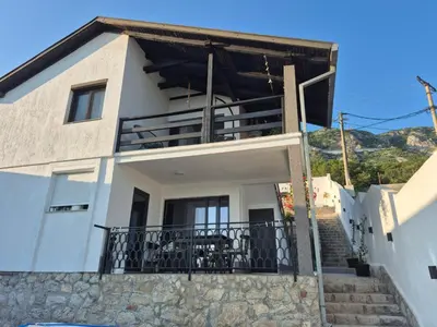 a white house with stairs leading up to it at CASA HOME, one-bedroom home in Stanišiči