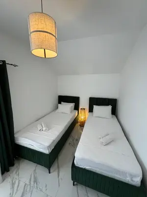 two beds sitting in a room with a lamp at CASA HOME, one-bedroom home in Stanišiči