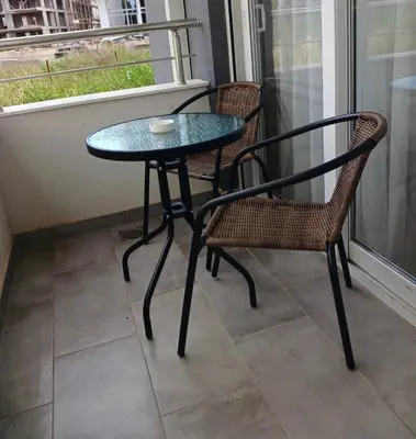 a glass table and two chairs on a balcony at L&D Apartments in Ulcinj
