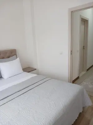 a white bed in a white room with a mirror at L&D Apartments in Ulcinj