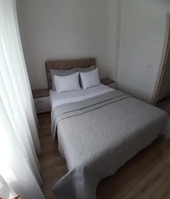 a white bed with two pillows in a room at L&D Apartments in Ulcinj