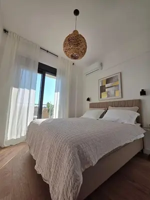 a bedroom with a large bed and a large window at Laurel apartment in Kravlja
