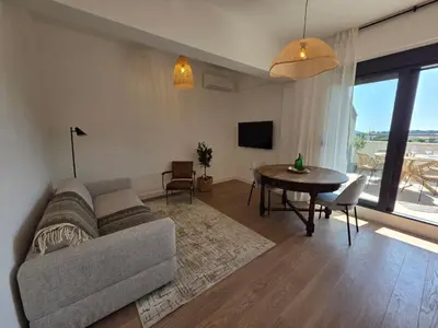 a living room with a couch and a table at Laurel apartment in Kravlja