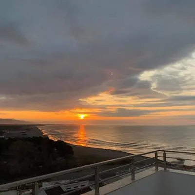 a sunset over the ocean from a balcony of a building at Aparments Plaza in Velika Plaža