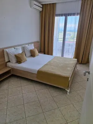 a bedroom with a bed and a large window at Aparments Plaza in Velika Plaža