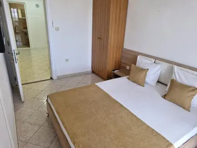 a bedroom with a large bed and a bathroom at Aparments Plaza in Velika Plaža