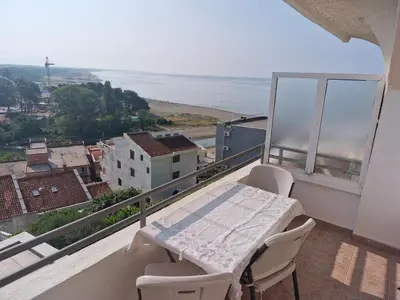 a balcony with a table and chairs and the ocean at Apartments Plaza in Ulcinj