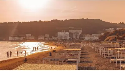 a beach with a group of people on the sand at Apartments Plaza in Ulcinj