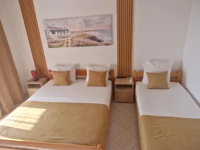two beds in a small room with a painting on the wall at Apartments Plaza in Ulcinj