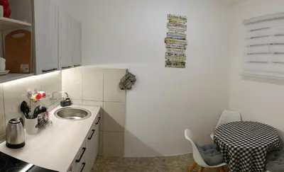 a small kitchen with a sink and a table at Tea23 in Kotor
