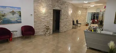 a lobby with a cat sitting on a counter and a brick wall at Hotel Porto Otrant in Ulcinj