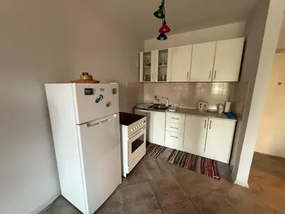 a kitchen with white cabinets and a white refrigerator at Emines apartman Budva in Budva