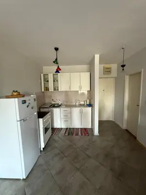 a kitchen with white cabinets and a white refrigerator at Emines apartman Budva in Budva