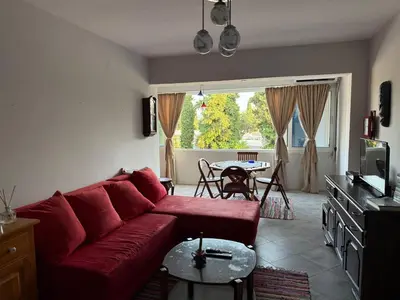 a living room with a red couch and a table at Emines apartman Budva in Budva