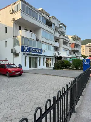 a red car parked in front of a building at Emines apartman Budva in Budva