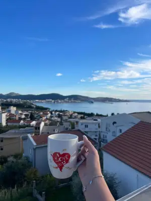 a woman holding a coffee cup with a heart on it at LazArina Apartments in Bar