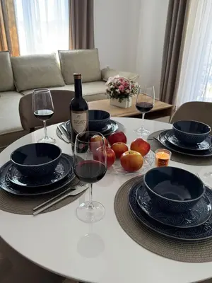 a table with glasses of wine and a bottle of wine at LazArina Apartments in Bar