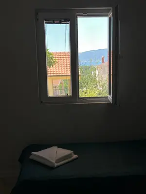 a window with a towel on a bed in a room at Vista Boka New Luxury Apartment in Kotor in Kotor