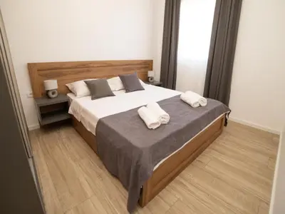 a bedroom with a large bed with towels on it at Nikola apartmani in Ulcinj