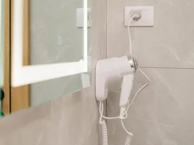a white phone hanging on a wall in a bathroom at Nikola apartmani in Ulcinj