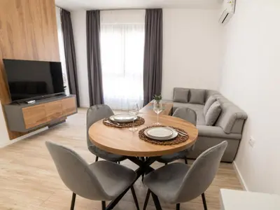 a living room with a table and chairs and a couch at Nikola apartmani in Ulcinj
