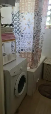 a bathroom with a washing machine and a shower curtain at Coco Apartment in Dobrota