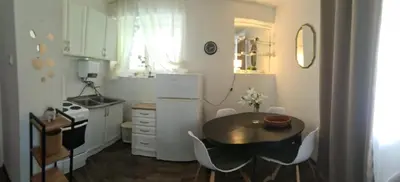 a small kitchen with a table and a refrigerator at Coco Apartment in Dobrota