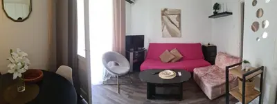 a living room with a pink couch and a table at Coco Apartment in Dobrota