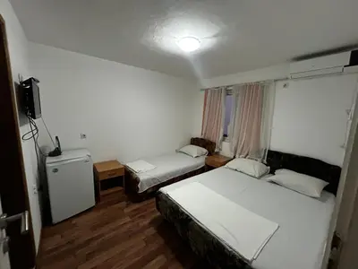 a hotel room with two beds and a television at Apartmani Musić in Ulcinj
