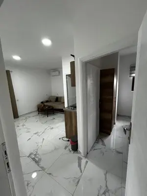 a living room with a marble floor and a kitchen at Apartmani Musić in Ulcinj