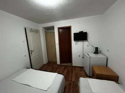 a small room with two beds and a television at Apartmani Musić in Ulcinj