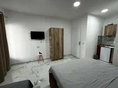 a bedroom with a bed and a tv on the wall at Apartmani Musić in Ulcinj