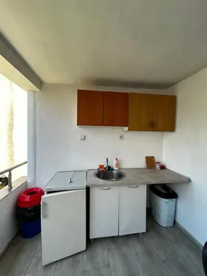 a small kitchen with a sink and wooden cabinets at Apartmani Musić in Ulcinj