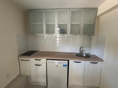 a small kitchen with white cabinets and a sink at studio Oliva home in Utjeha