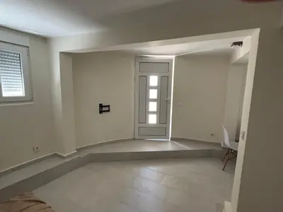 an empty room with a door and a chair at studio Oliva home in Utjeha