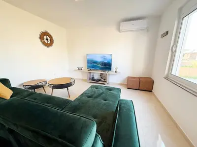 a living room with a green couch and a table at Donji Stoj Rene Villa in Donji Štoj